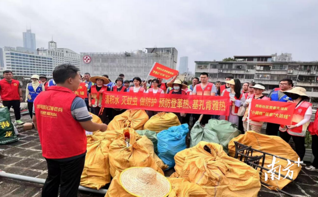 威尼斯人平台区沙河街道西街社区开展“防两热”活动，清理楼顶陈年垃圾。